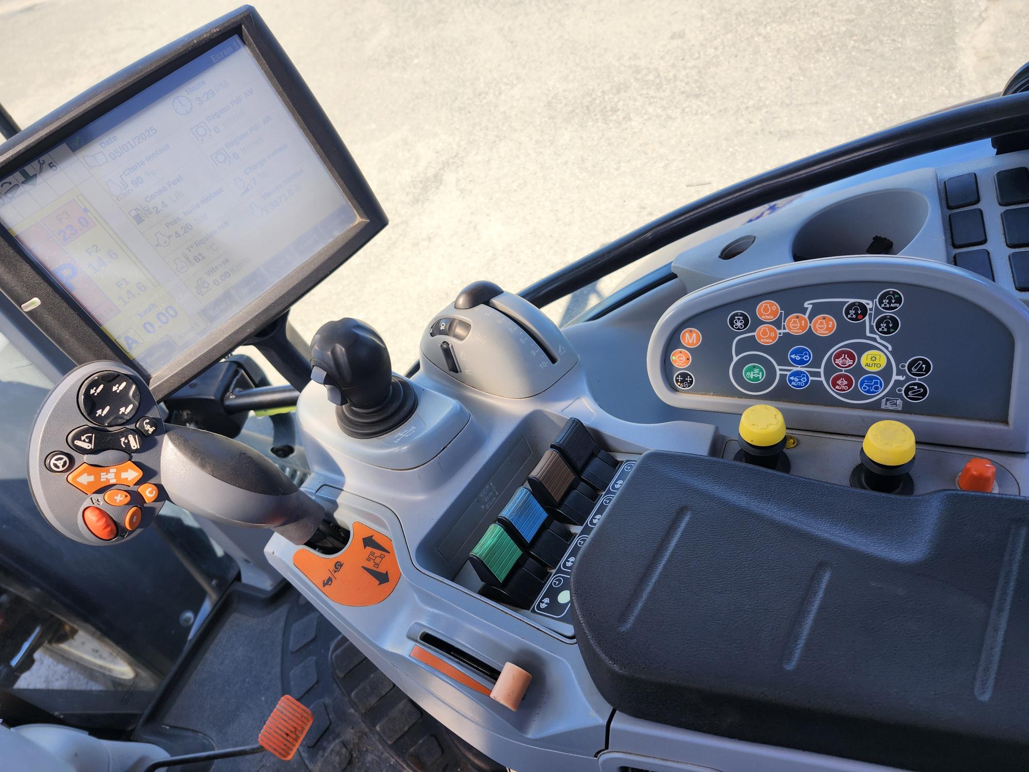 Gros plan d'un cockpit de tracteur moderne montrant un écran tactile, un joystick, plusieurs boutons, cadrans et commandes sur un panneau à côté du siège du conducteur, tous conçus pour faire fonctionner et surveiller les machines.