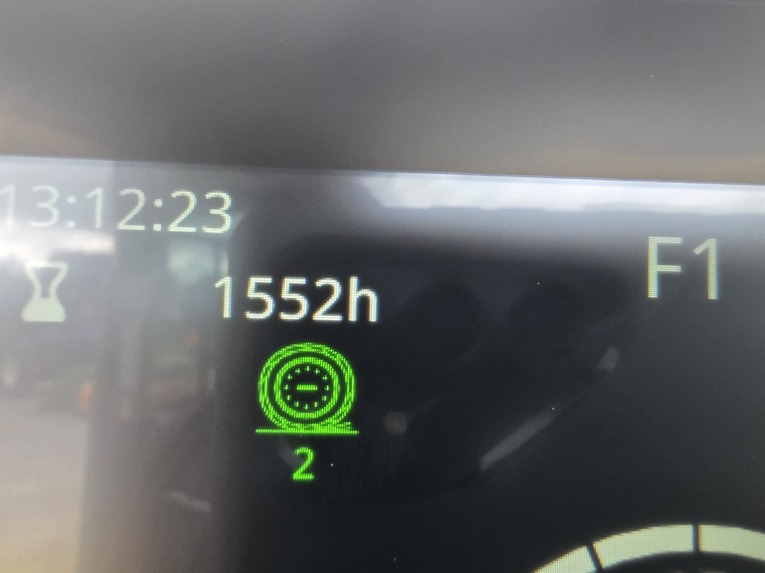 Un écran numérique affiche l'heure « 13:12:23 », « 1552 h », la lettre « F1 » et une icône verte surmontée du chiffre « 2 », indiquant les heures de fonctionnement de l'équipement et son état de fonctionnement.
