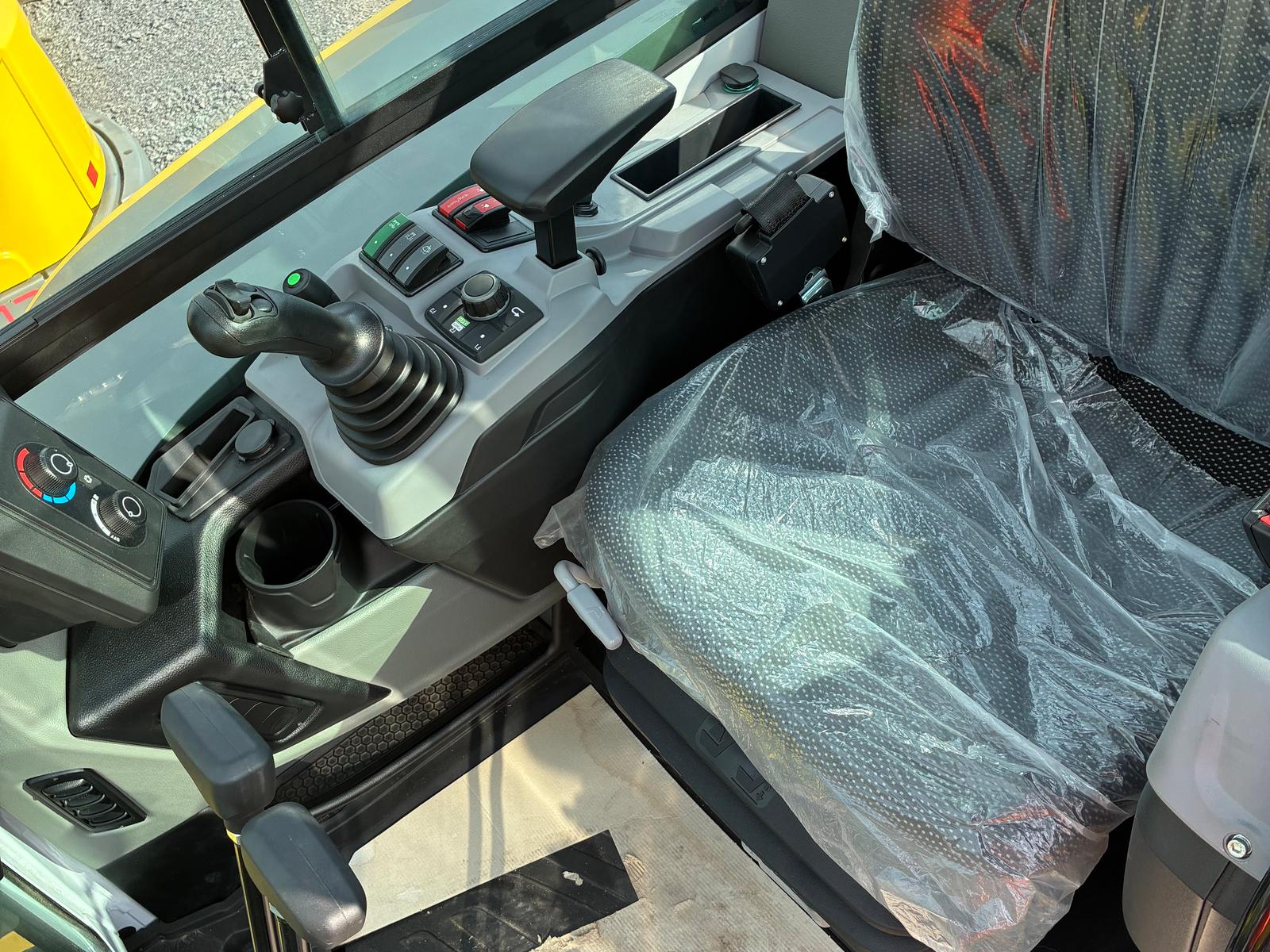 ET42, intérieur de la cabine, siège protégé d'une housse plastique et commandes au joystick