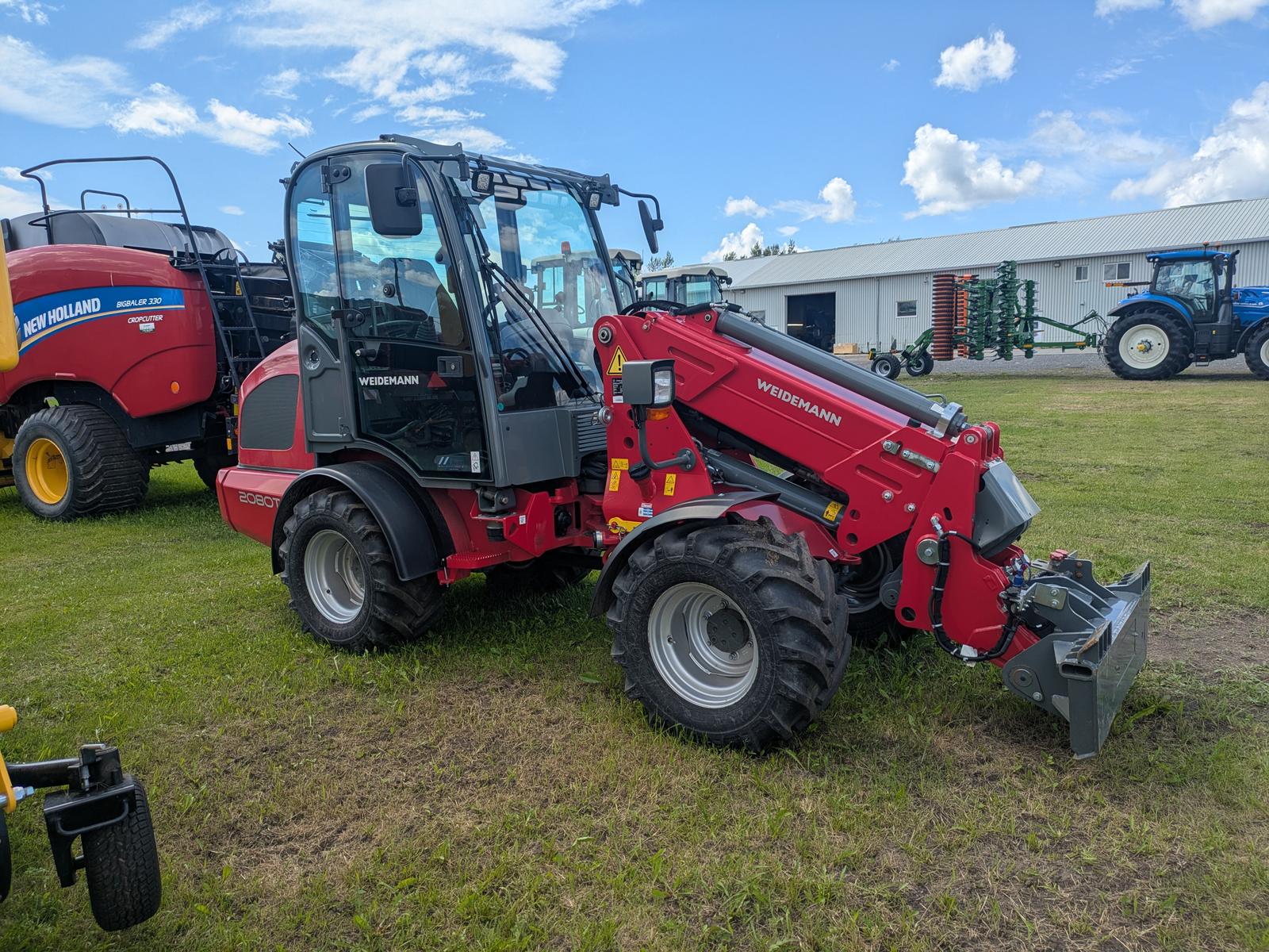 Weidemann 2080T vu de trois quarts avant-gauche, sans accessoire attelé, ciel dégagé en arrière-plan