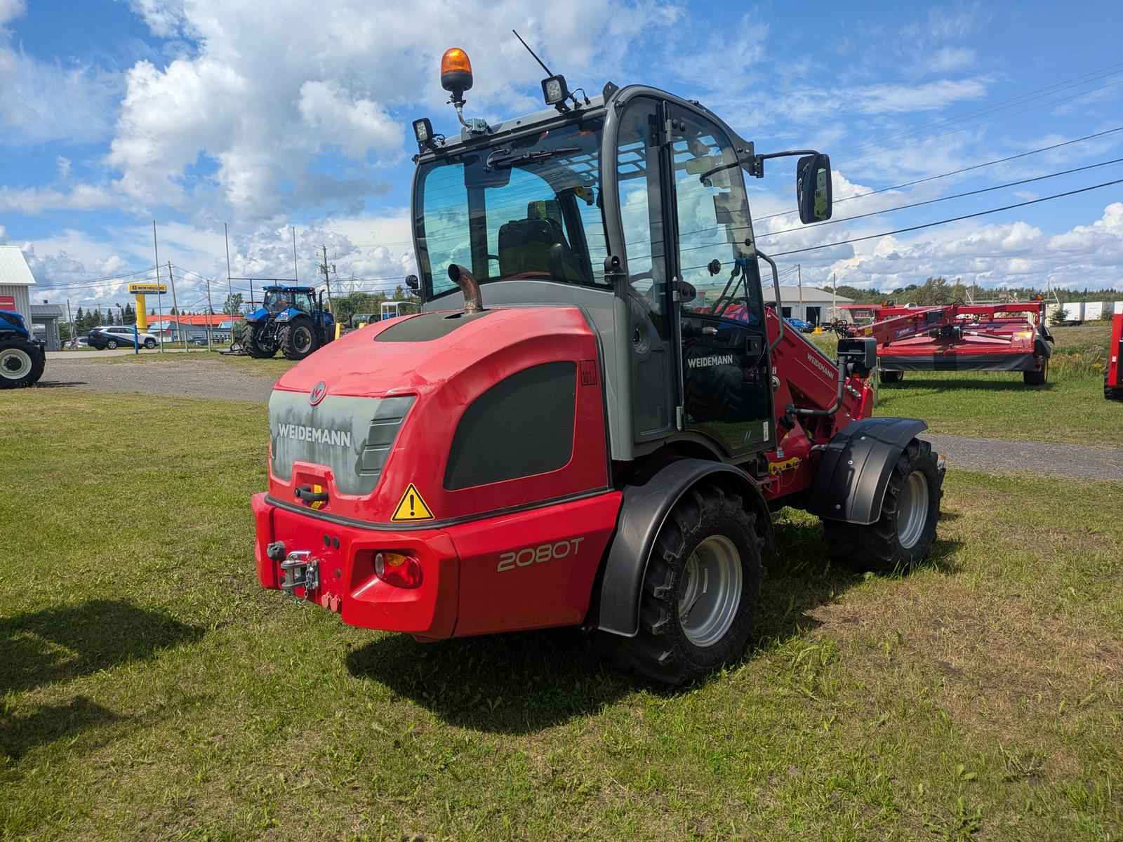 Weidemann 2080T vu de trois quarts arrière, gyrophare visible sur le toit de la cabine