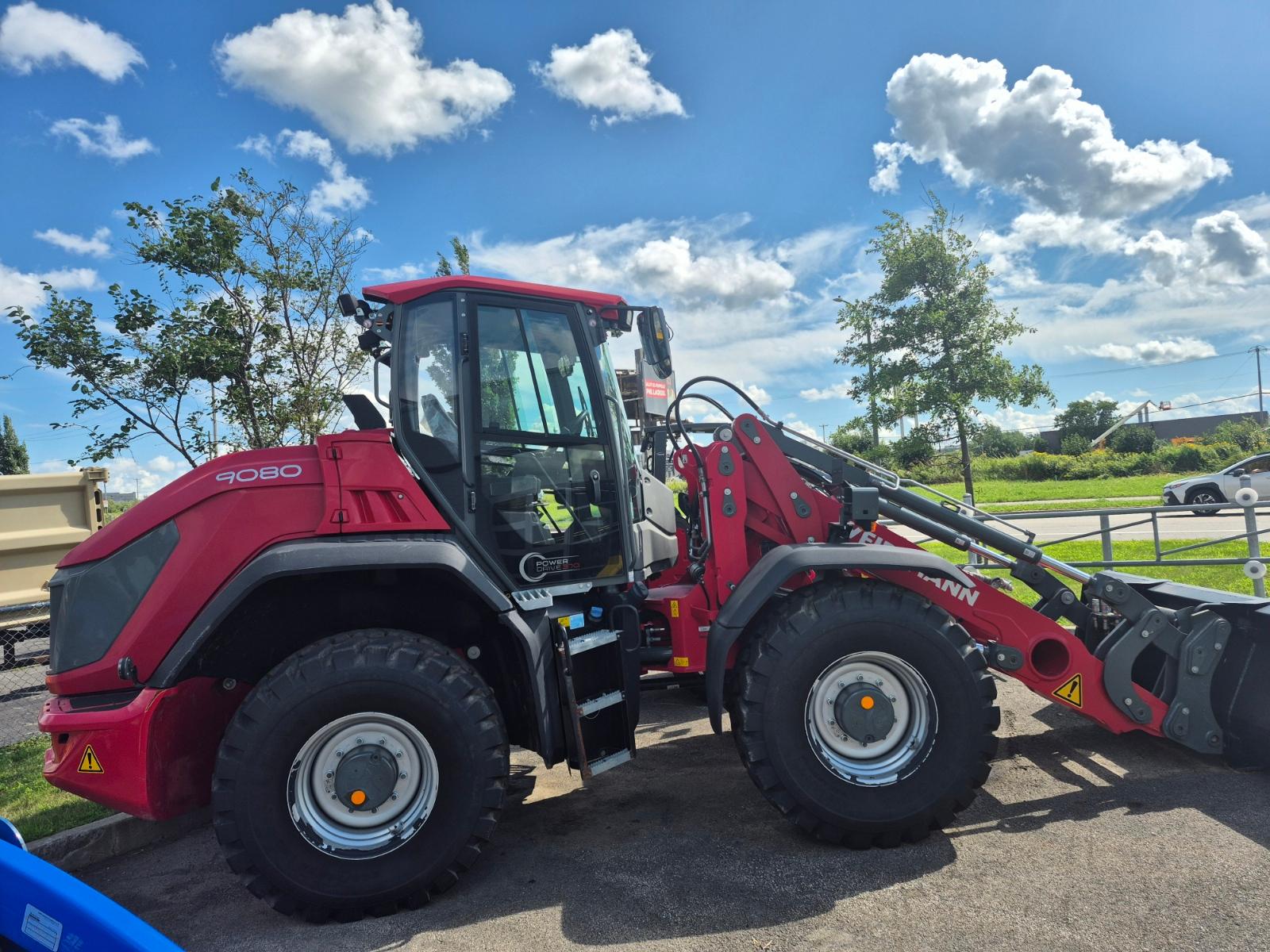 Weidemann 9080 vu de côté, godet à l'avant, sur le stationnement asphalté