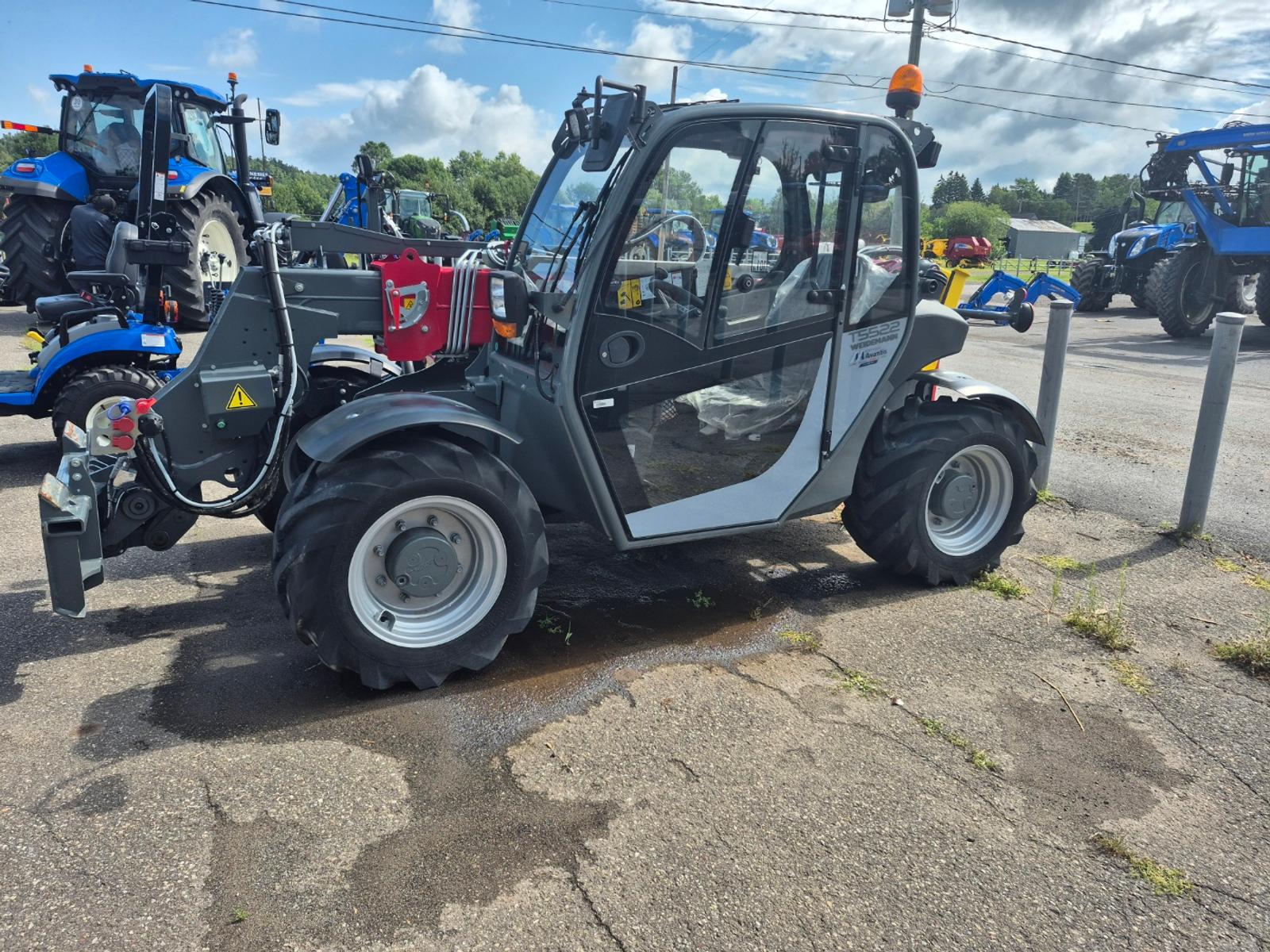 Weidemann T5522 vu de côté, carrosserie grise, bras télescopique replié contre la cabine