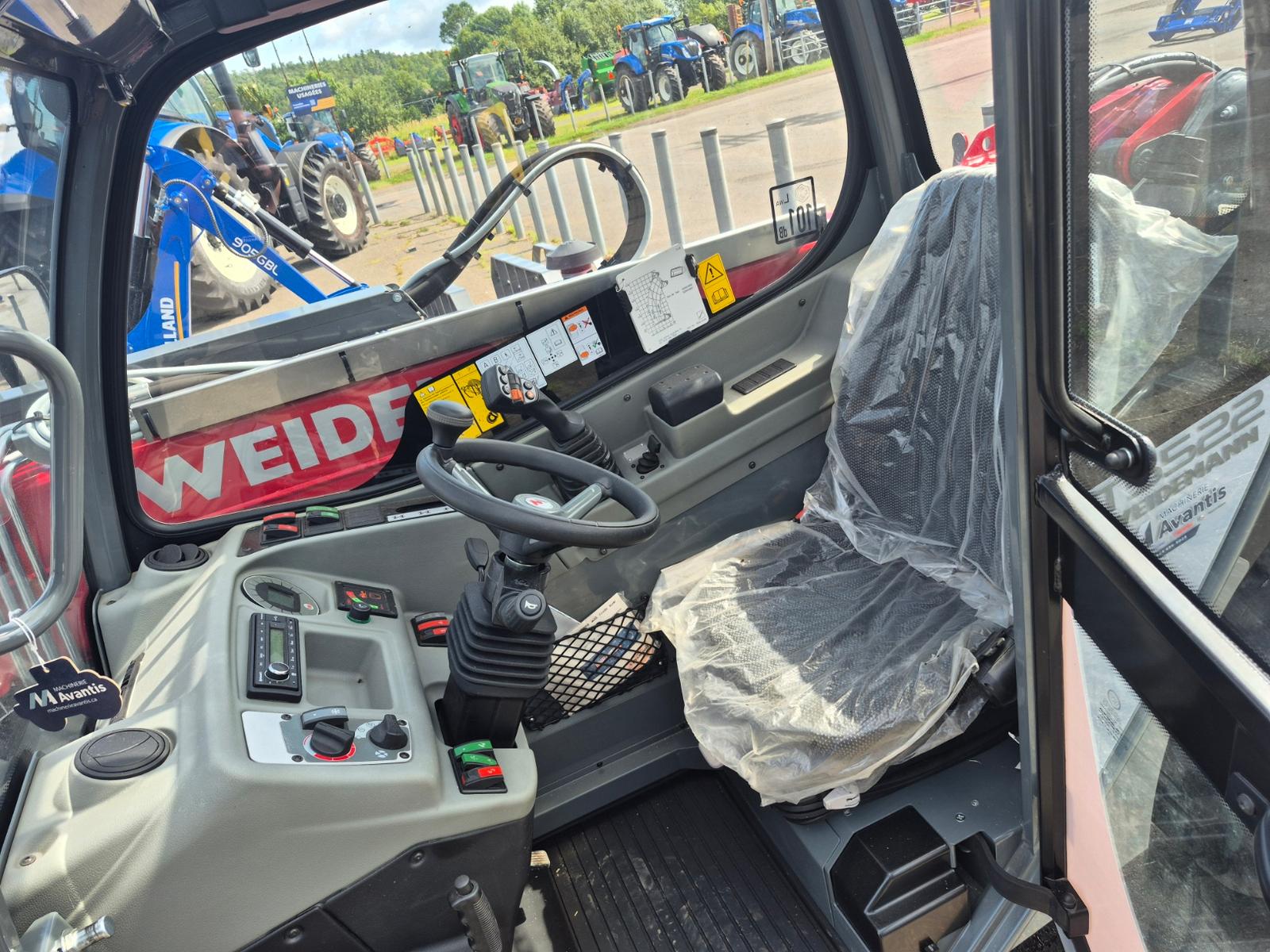 Weidemann T5522, intérieur de la cabine, siège protégé d'une housse plastique et commandes au joystick