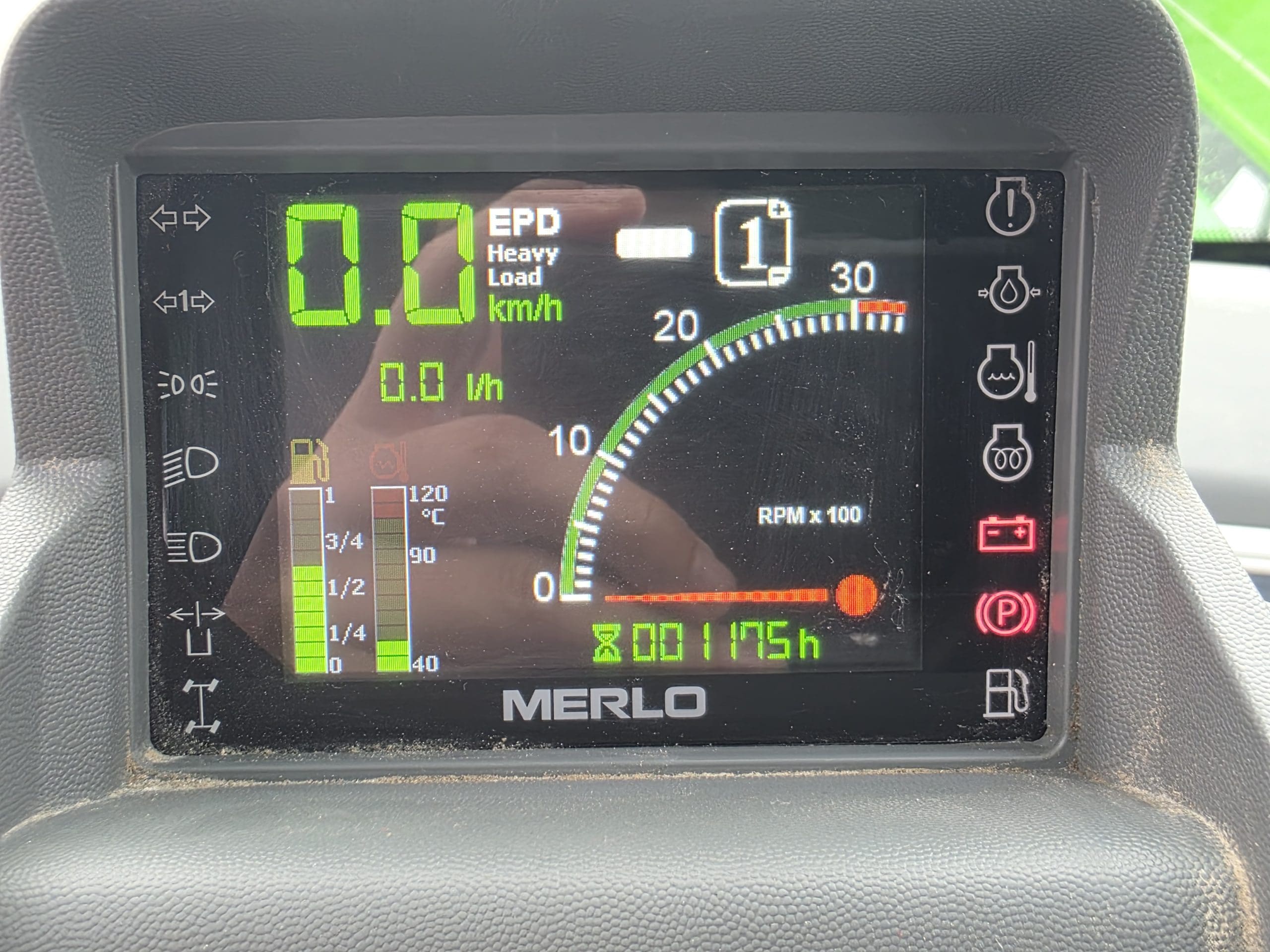 Tableau de bord numérique affichant la vitesse du véhicule, le rapport engagé, le niveau de carburant, le régime moteur, les voyants d'alerte et les heures de fonctionnement. Le cadran principal indique 0,0 km/h, le rapport 1, un régime moteur légèrement supérieur à 0 et 1 175 heures. Diverses icônes s'affichent sur le côté droit.