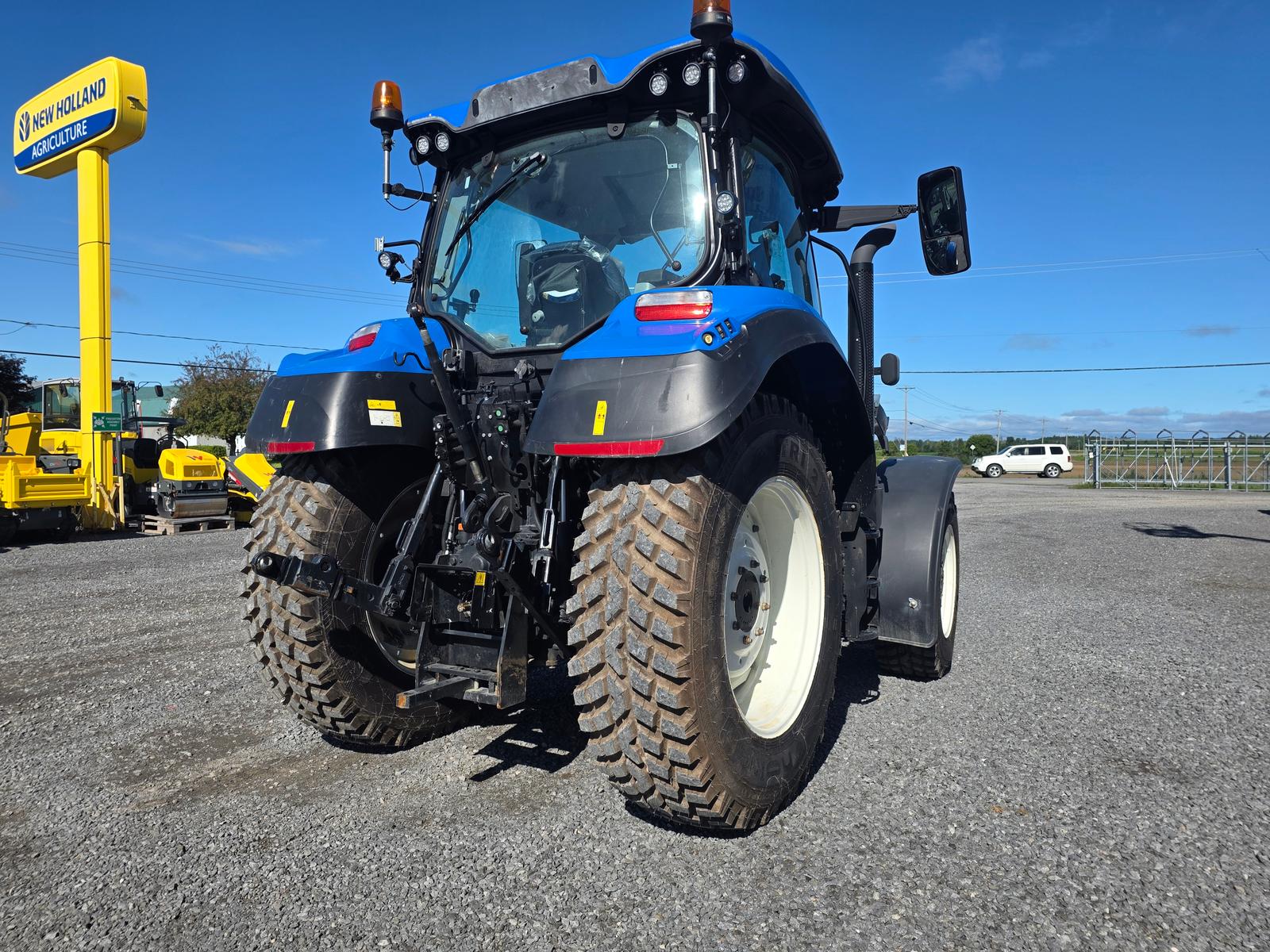 New Holland T5 vu de trois quarts arrière-droit, attelage trois points et prise de force visibles